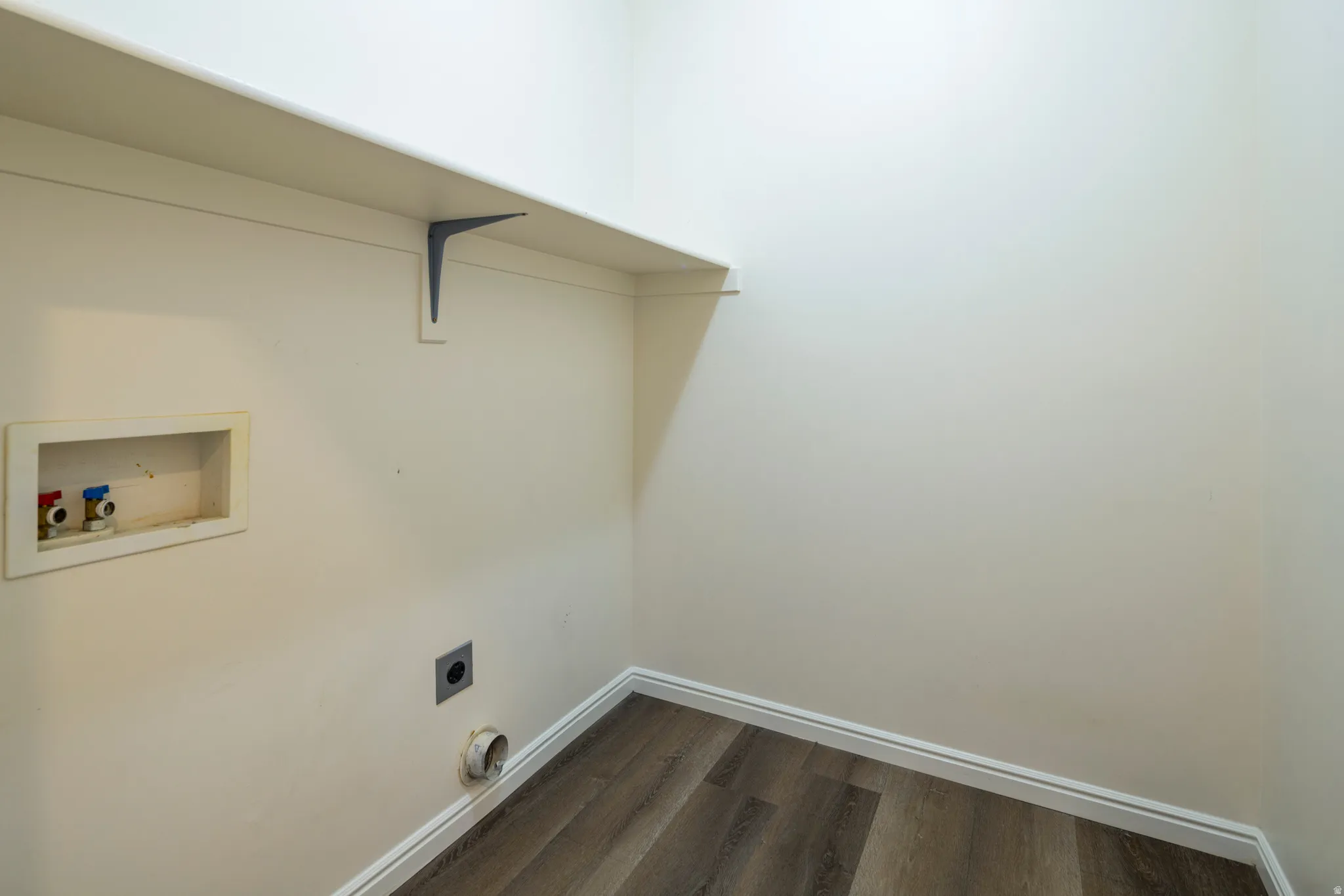 Laundry area with electric dryer hookup, dark wood finished floors, and washer hookup