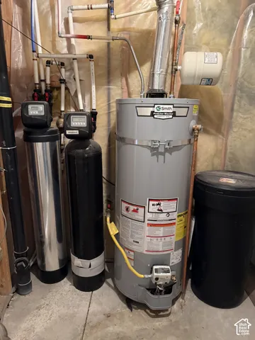 Water heater, water softener system, and associated plumbing visible