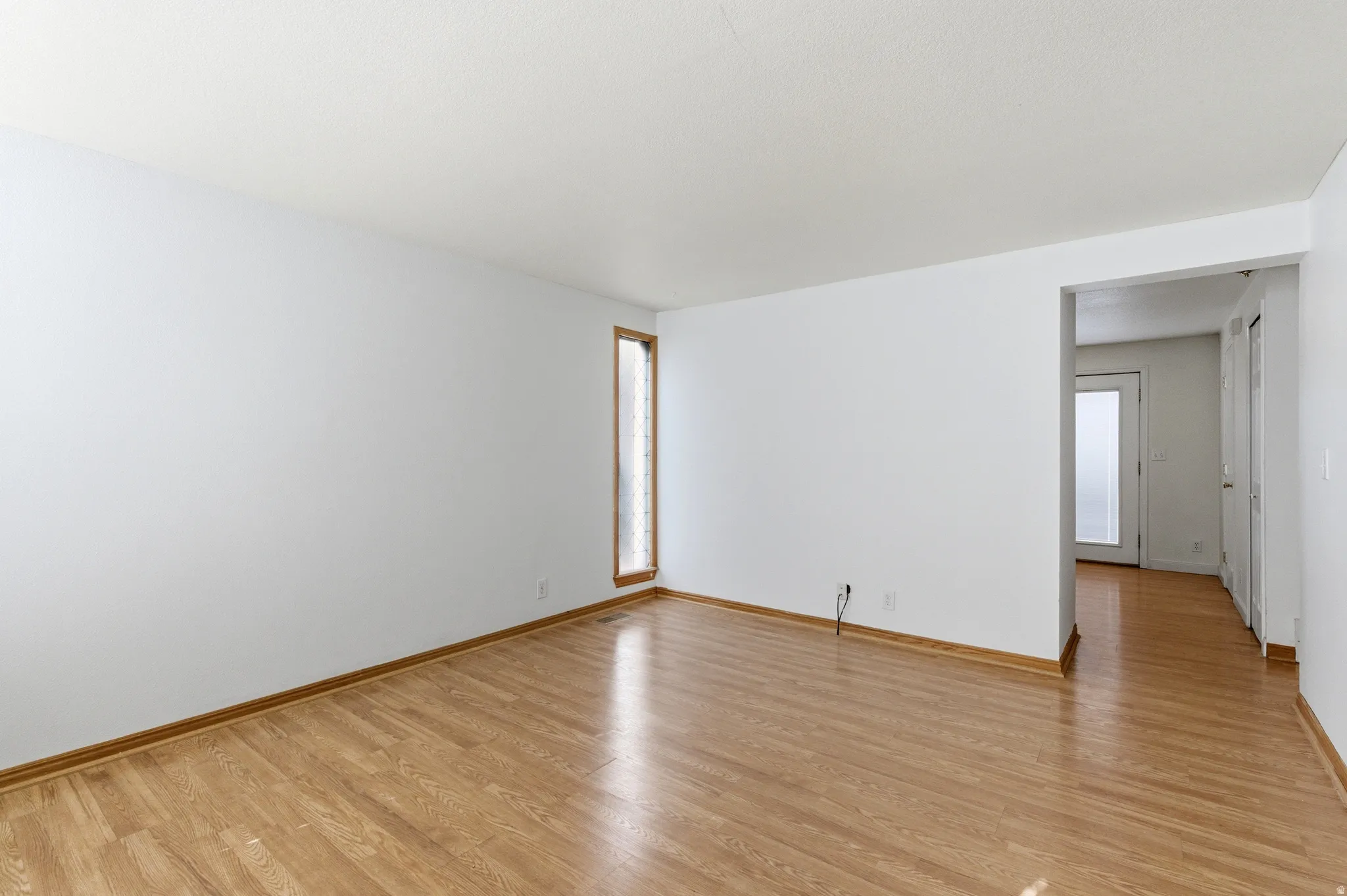 Unfurnished living room featuring wooden walls and wood finished floors