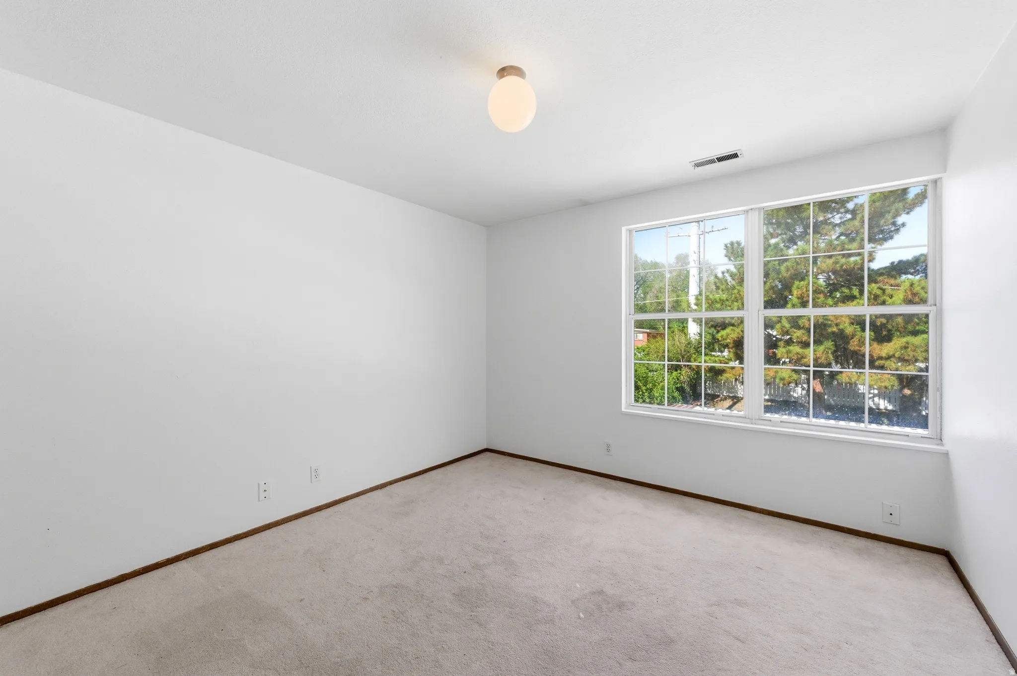 Bedroom with light carpet and baseboards