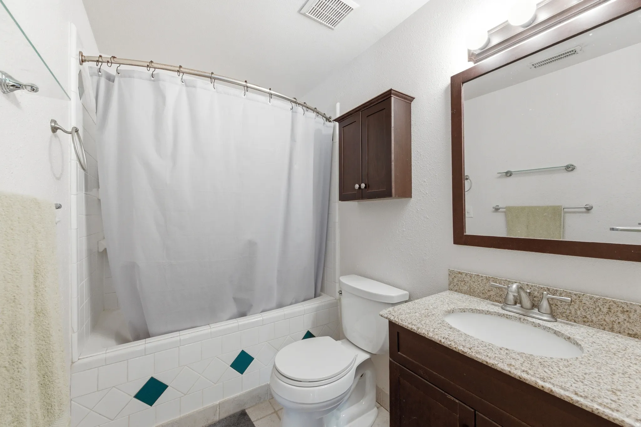 Bathroom featuring shower / bathtub combination with curtain and vanity