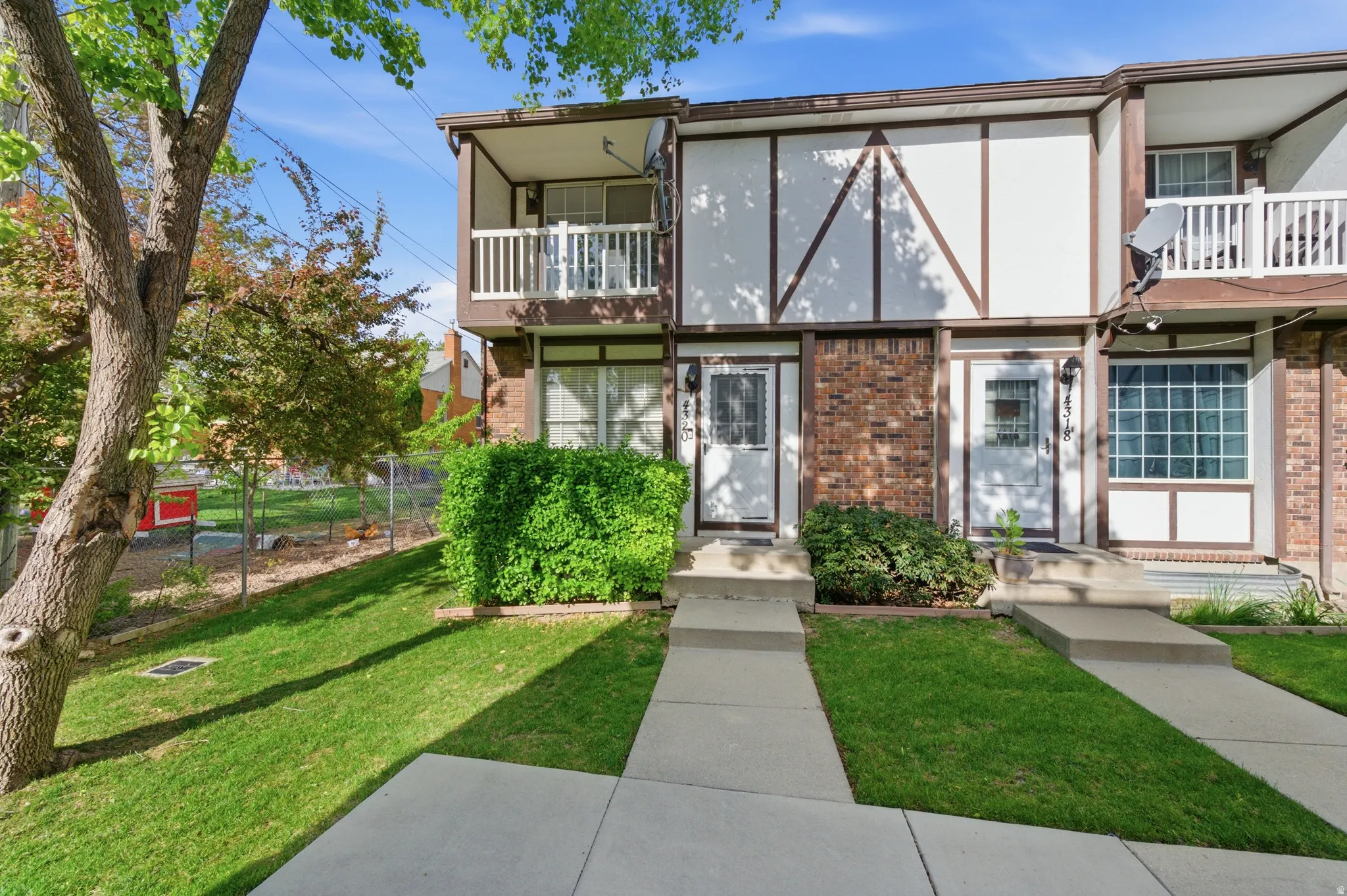 Tudor-style house with a balcony and brick siding