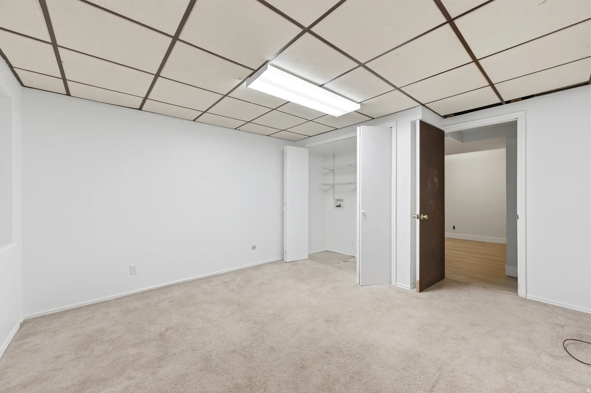 Living room with light colored carpet and a paneled ceiling