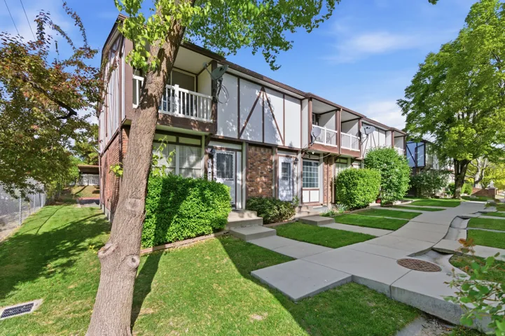 View of front facade with brick siding and a balcony