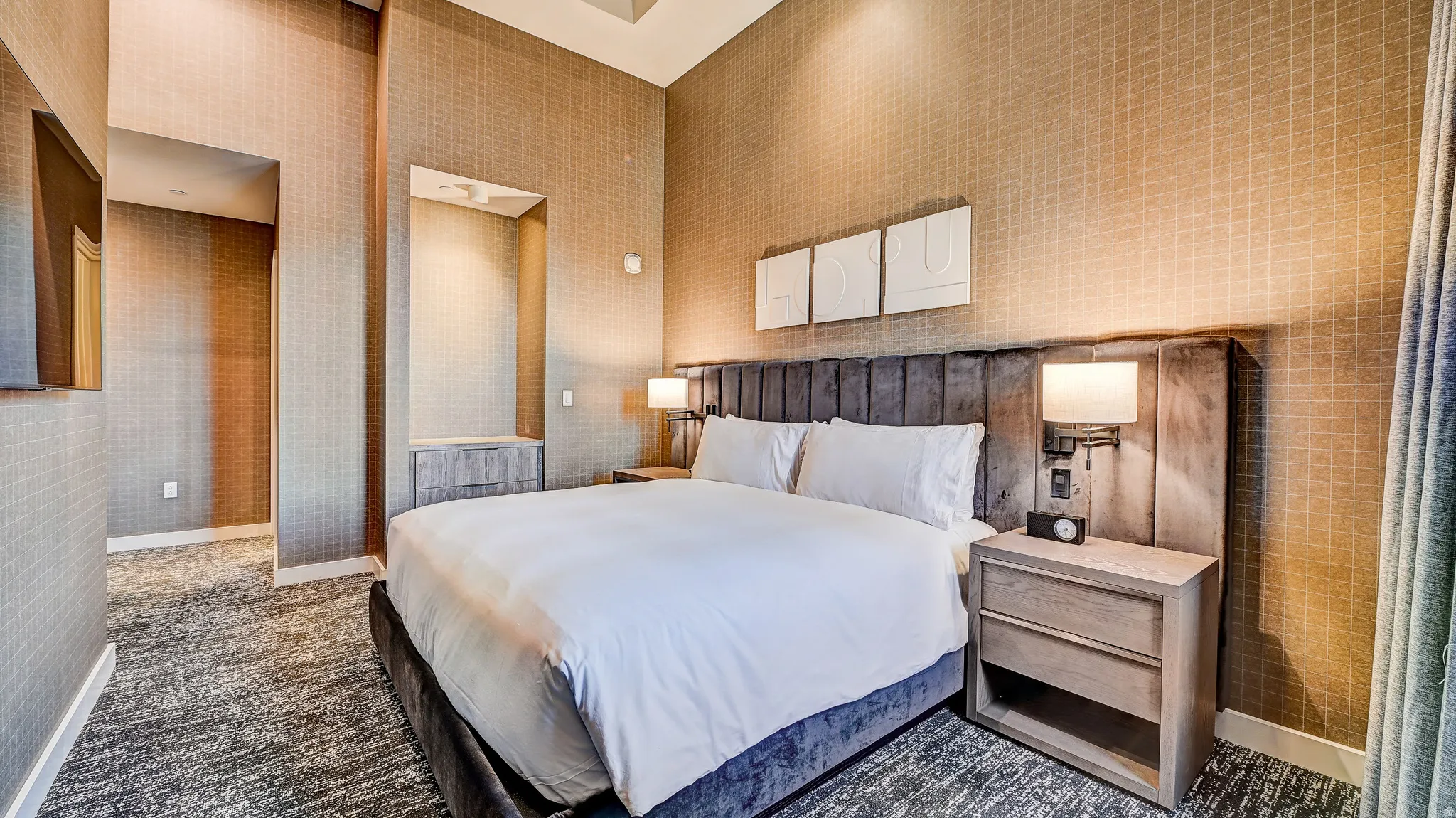 Bedroom with dark carpet and wallpapered walls