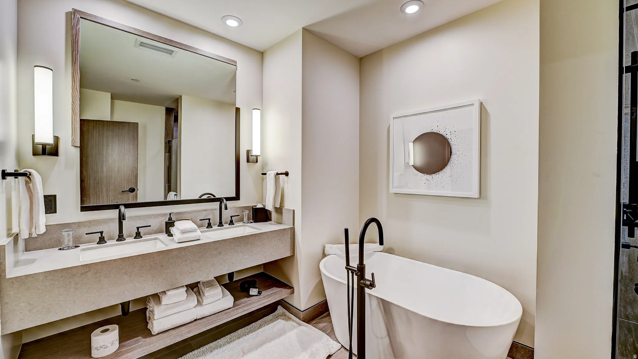 Full bathroom featuring double vanity, a freestanding tub, and recessed lighting