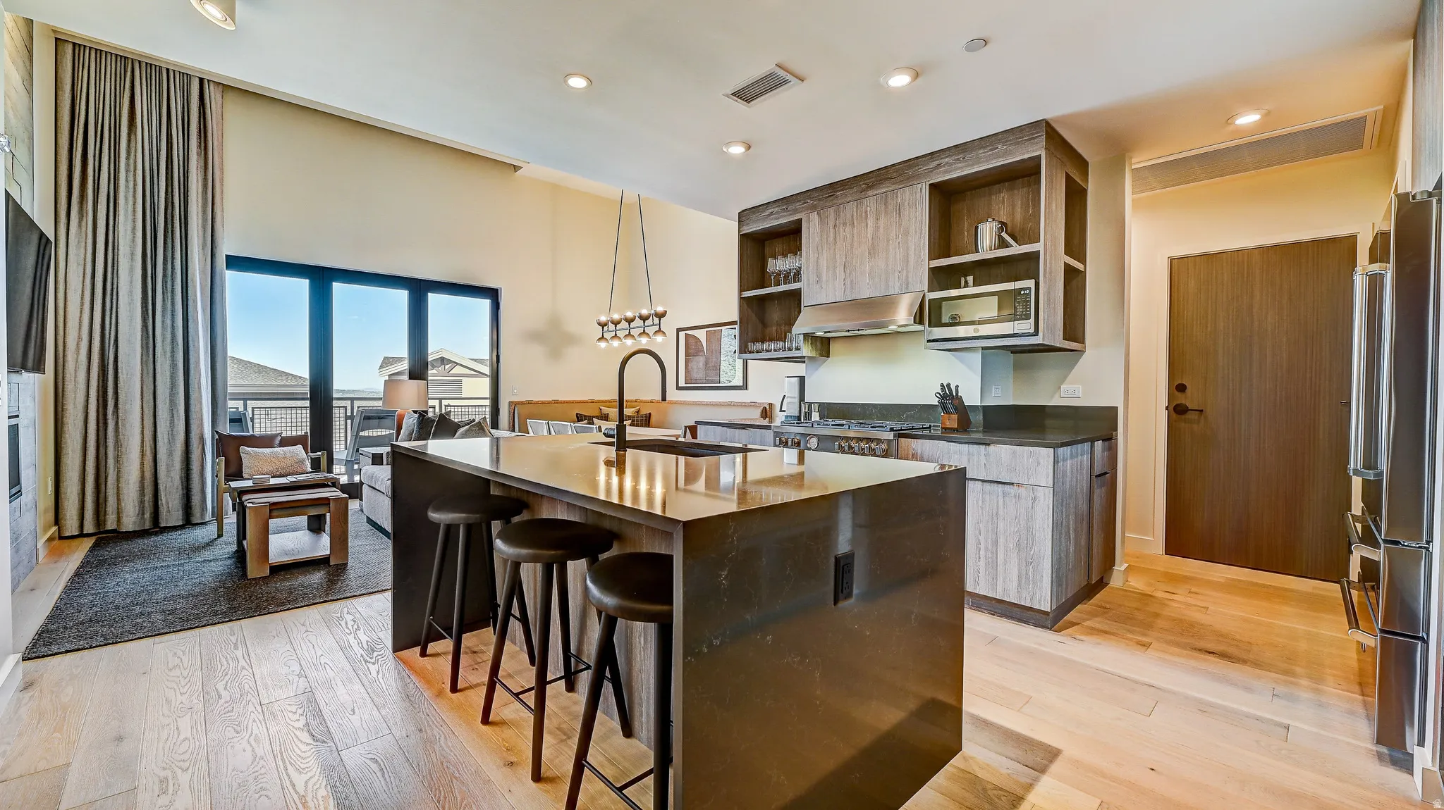 Kitchen featuring open shelves, dark stone countertops, a kitchen bar, light wood finished floors, and recessed lighting