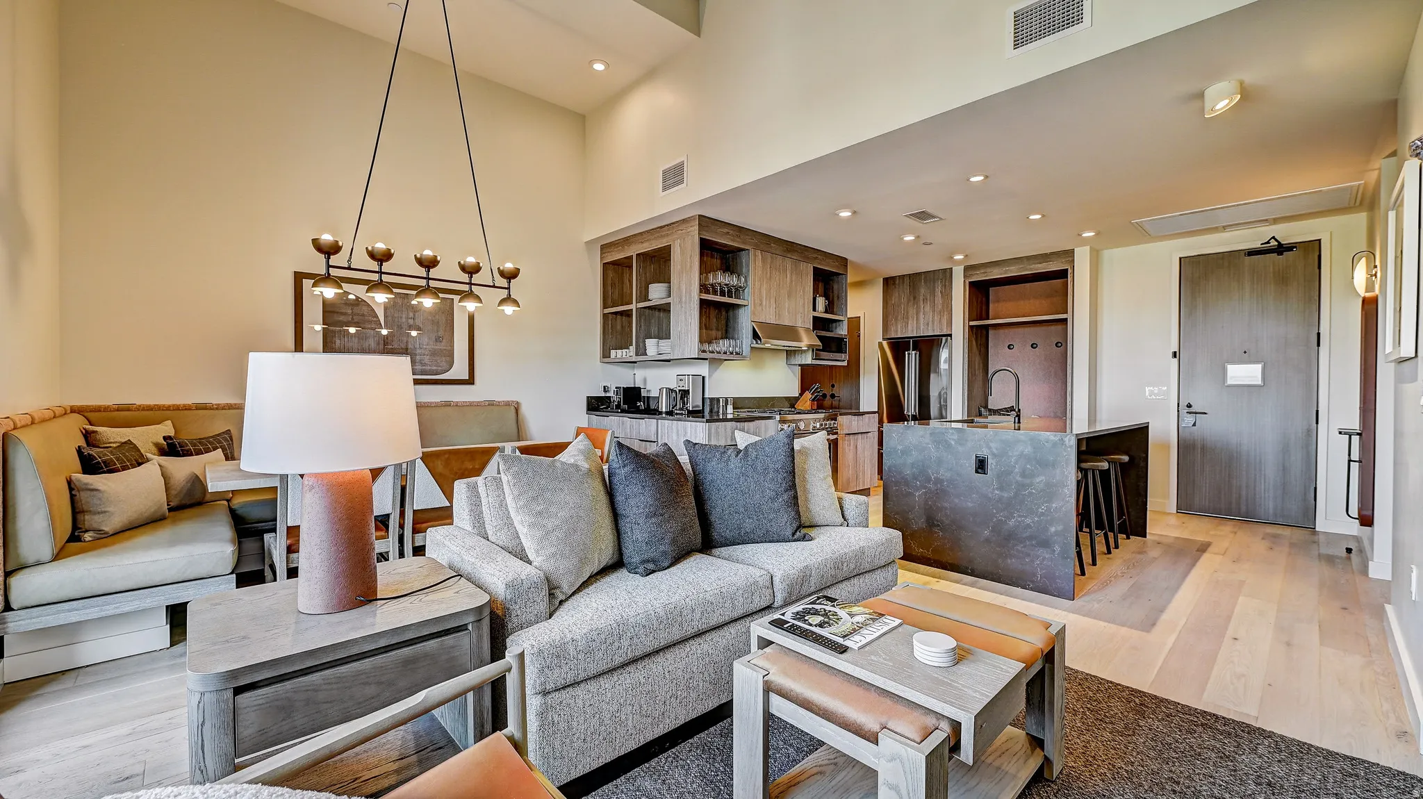 Living room featuring light wood-type flooring, a high ceiling, and recessed lighting