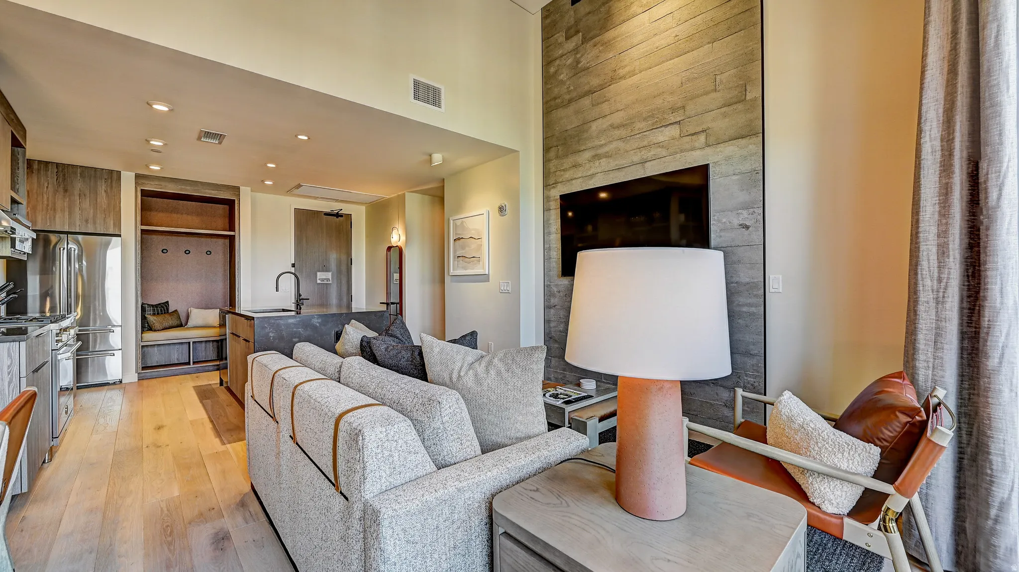 Living room featuring light wood finished floors, recessed lighting, and a high ceiling