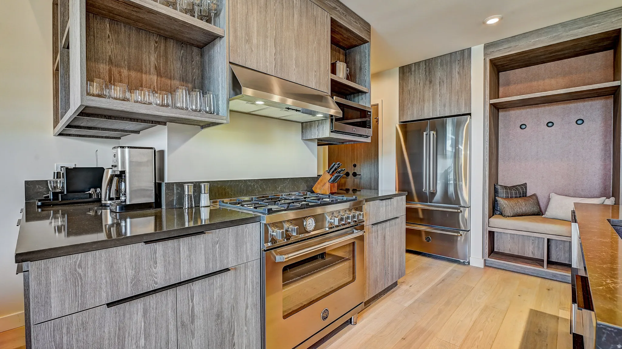 Kitchen featuring open shelves, high quality appliances, modern cabinets, light wood-style floors, and extractor fan