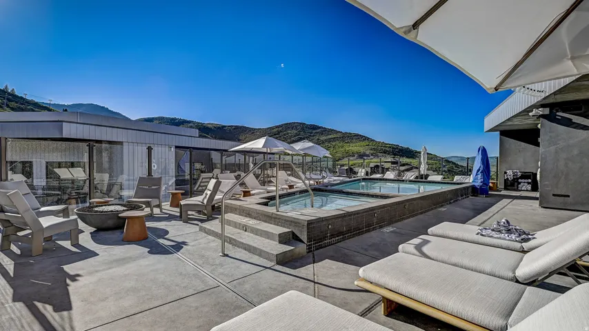 View of patio / terrace with an outdoor fire pit, a mountain view, and a community pool