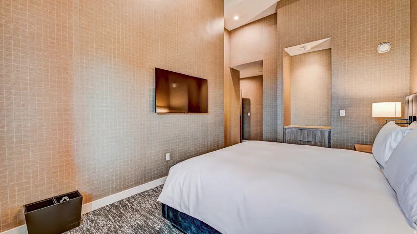 Bedroom featuring recessed lighting and wallpapered walls