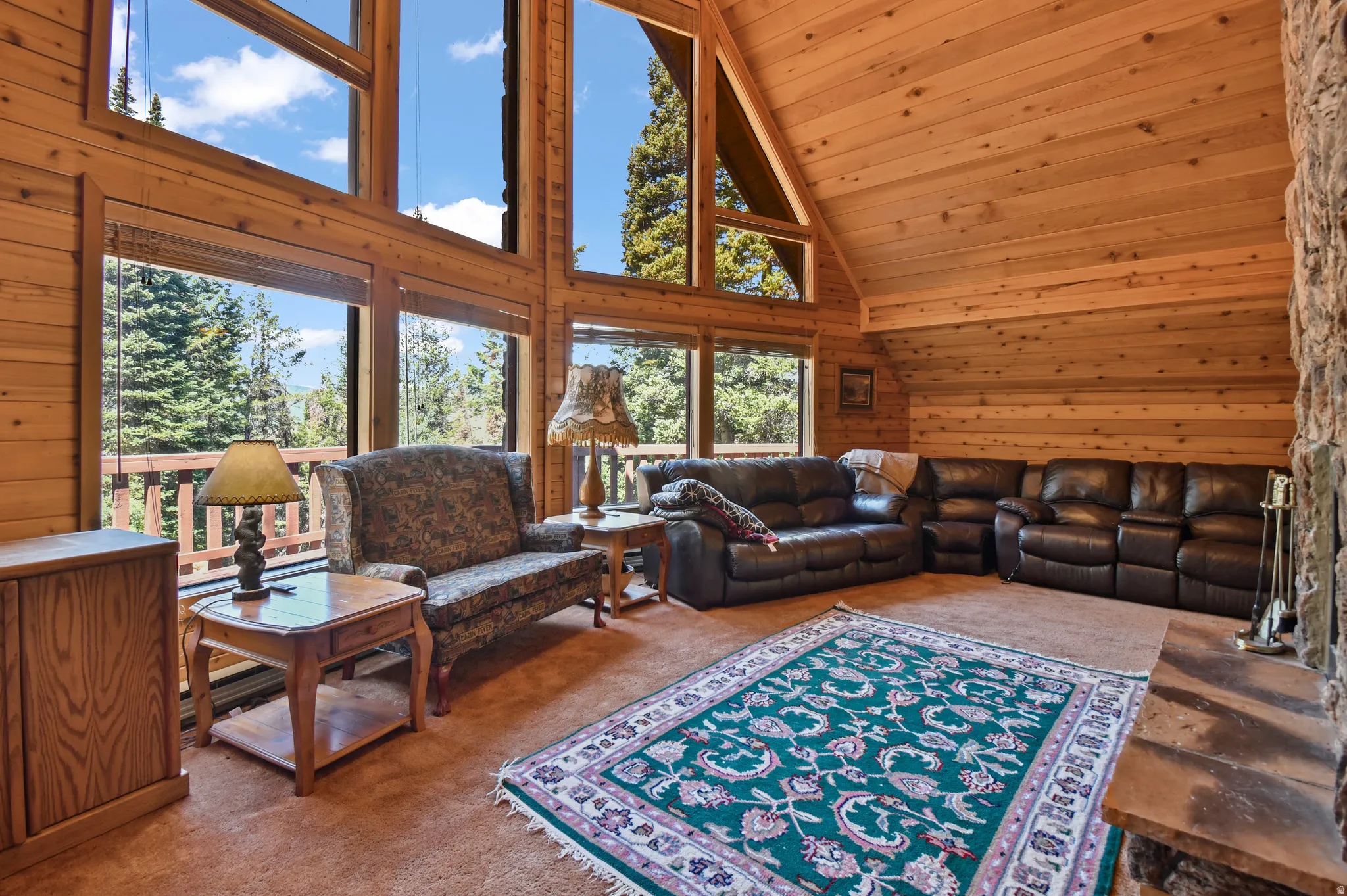 Living area featuring wooden walls, carpet floors, and a vaulted wooden ceiling
