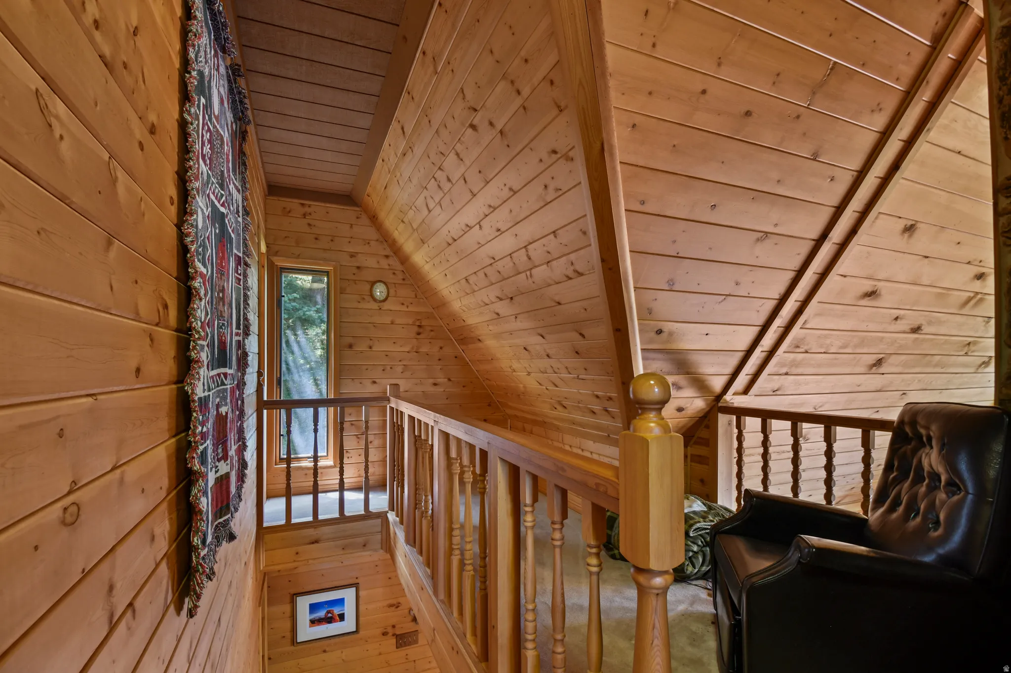 Hallway featuring a vaulted wood ceiling, wooden walls, an upstairs landing, and hardwood / wood-style floors