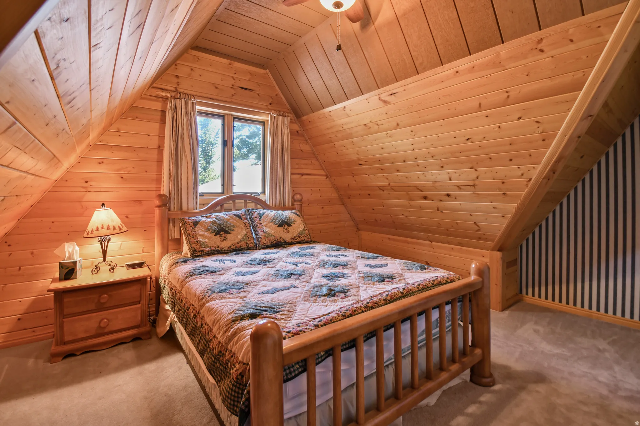 Carpeted bedroom with wooden ceiling, wood walls, and ceiling fan