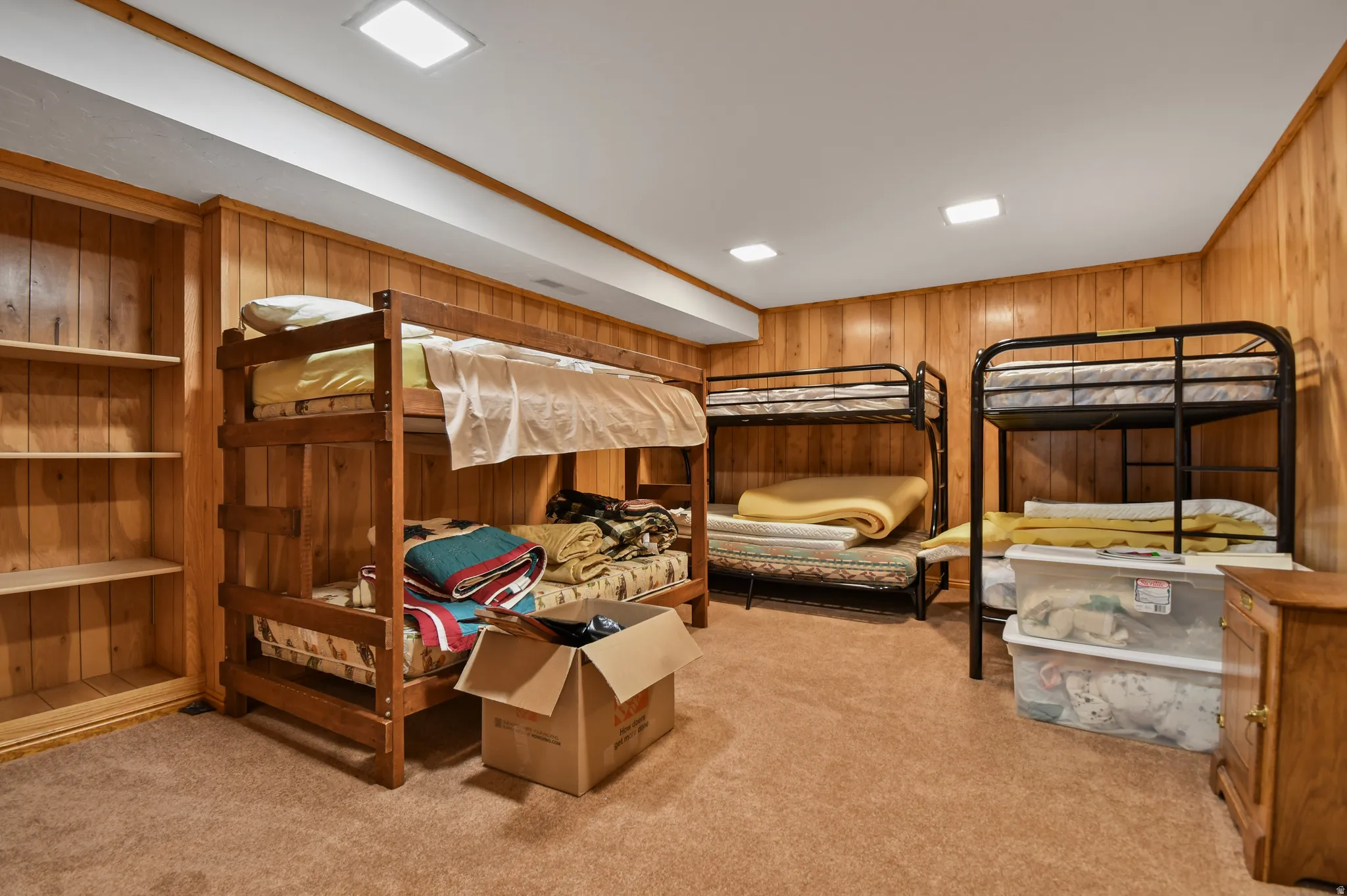 Bedroom featuring light colored carpet, wood walls, and recessed lighting