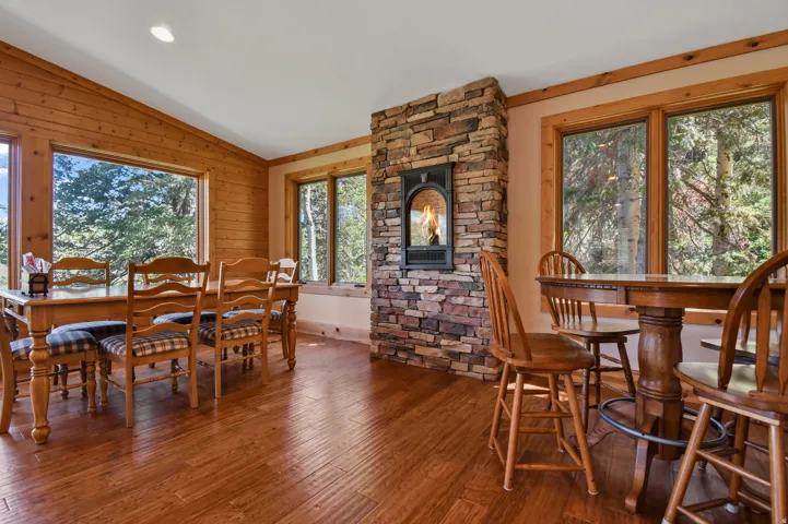 Dining area with hardwood / wood-style floors, vaulted ceiling, wooden walls, and recessed lighting