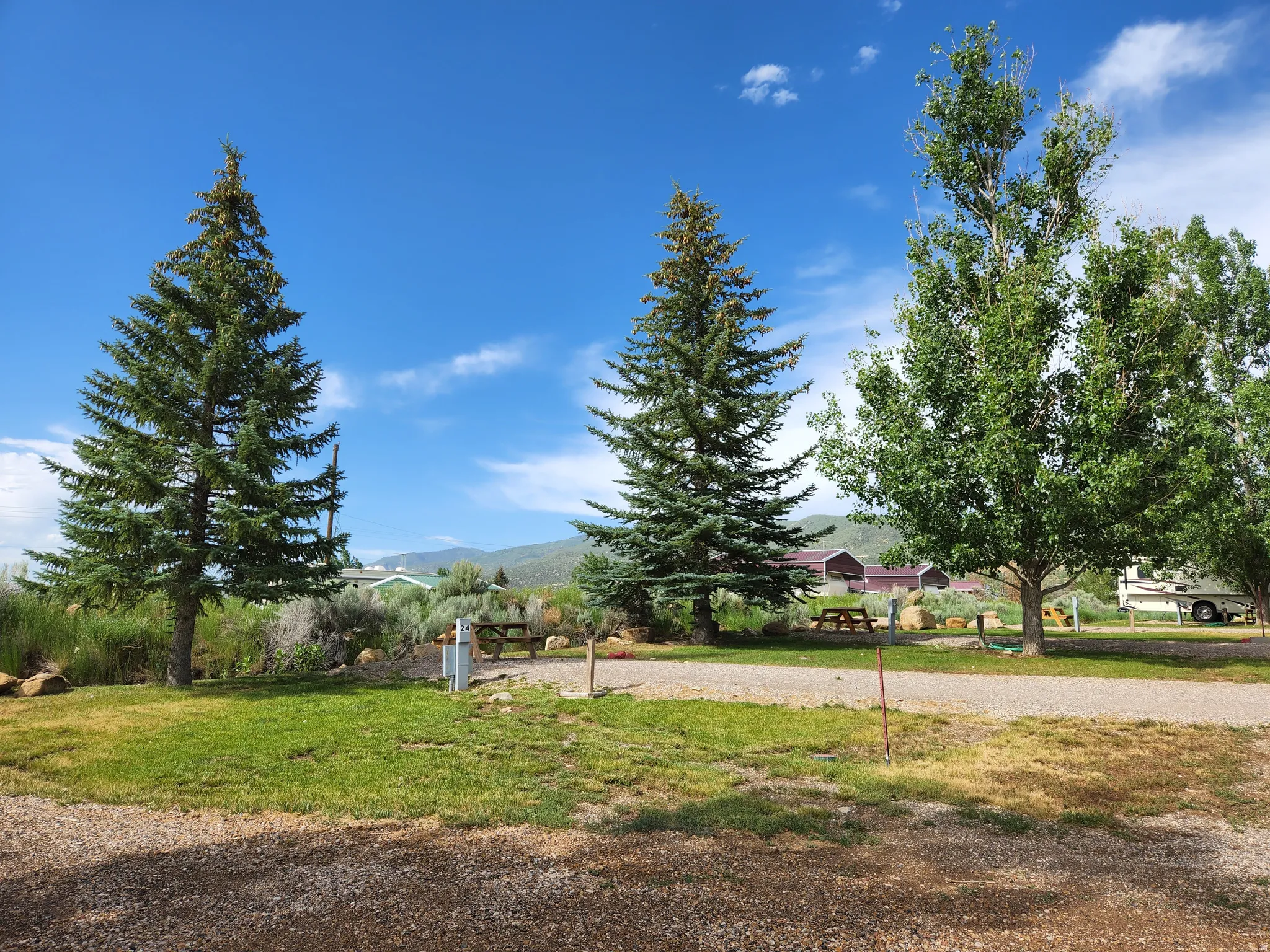 View of green lawn featuring volleyball court and a mountain view