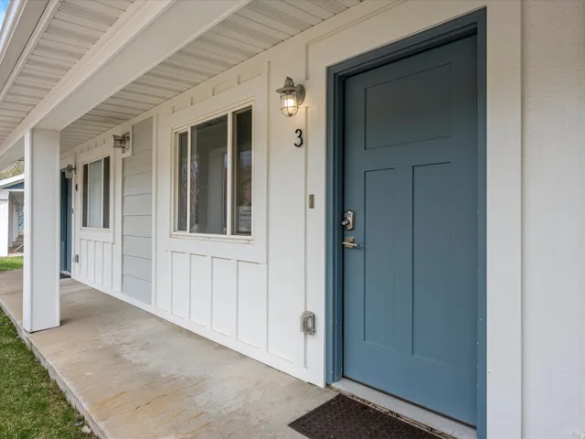 Property entrance featuring covered porch and board and batten siding