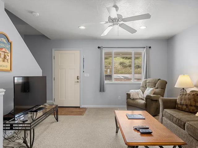 Living room featuring light colored carpet, ceiling fan, recessed lighting, and a textured ceiling