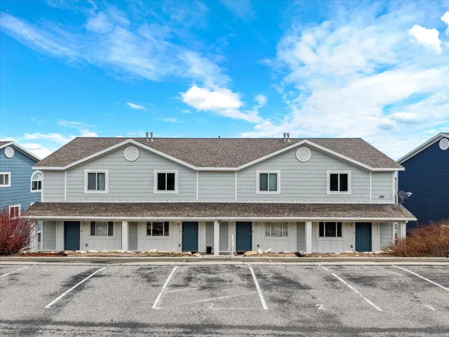 View of front of home featuring roof with shingles, uncovered parking, and board and batten siding