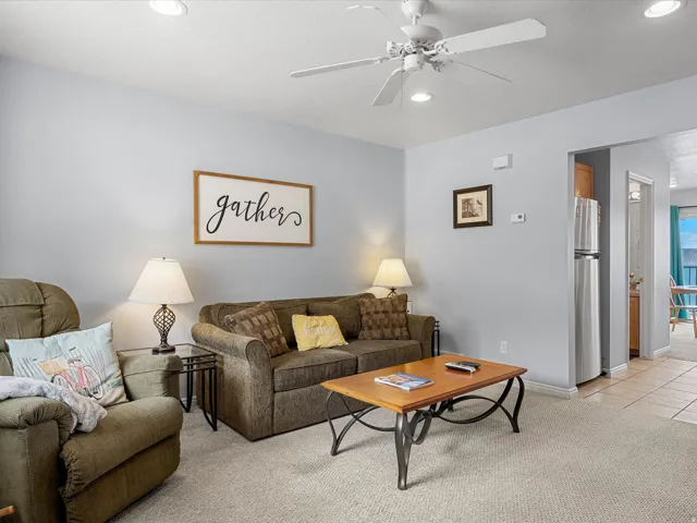Living area with light colored carpet, a ceiling fan, recessed lighting, and light tile patterned floors