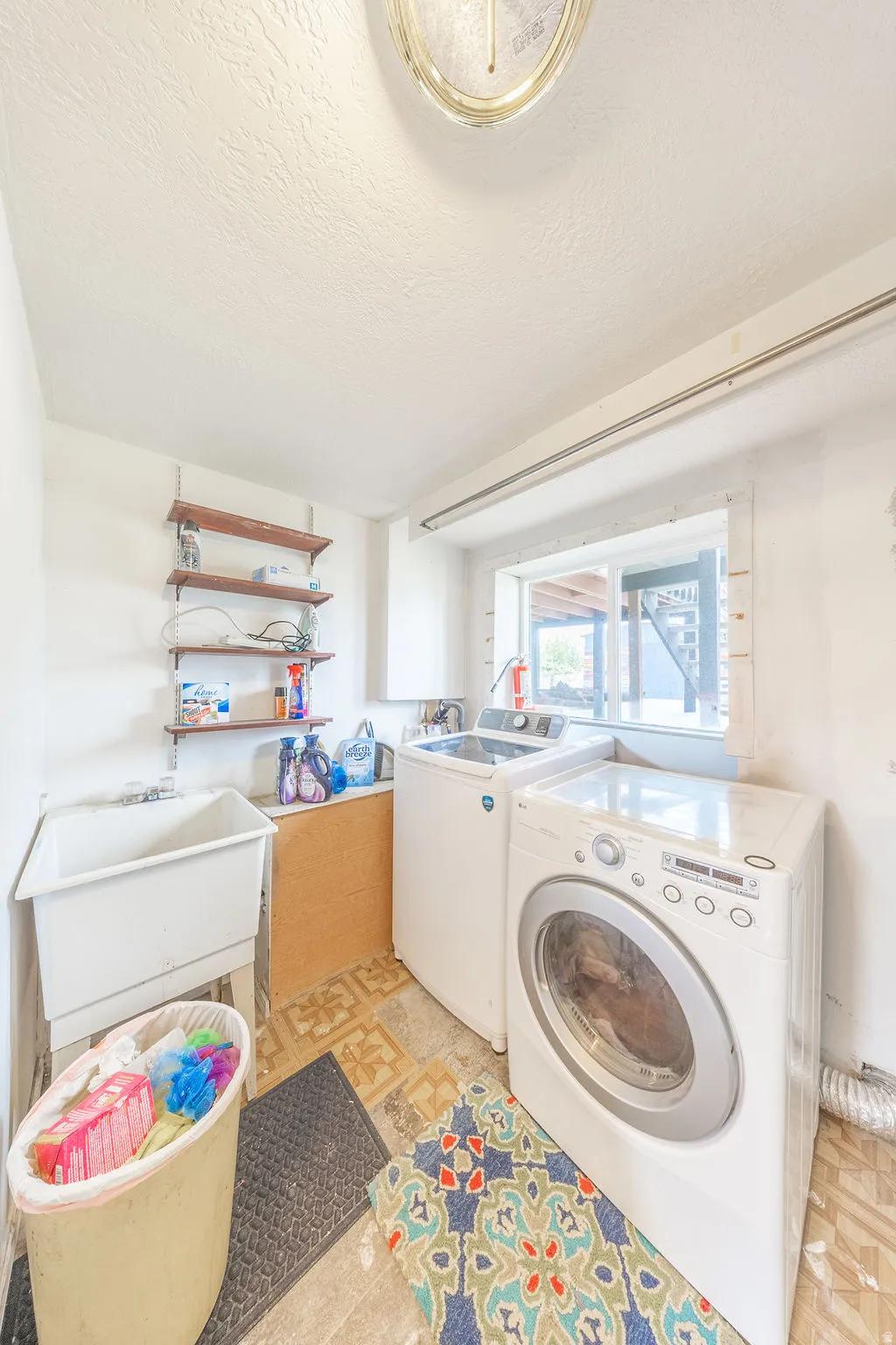 Laundry room featuring washer and dryer and a textured ceiling