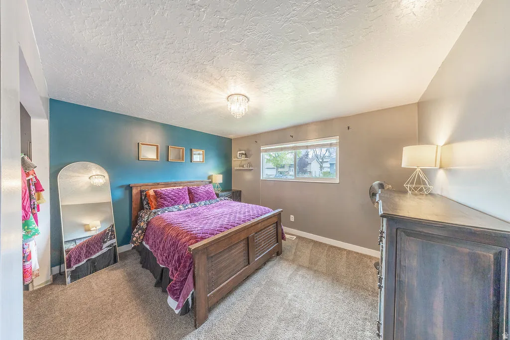 Bedroom featuring light carpet and a textured ceiling