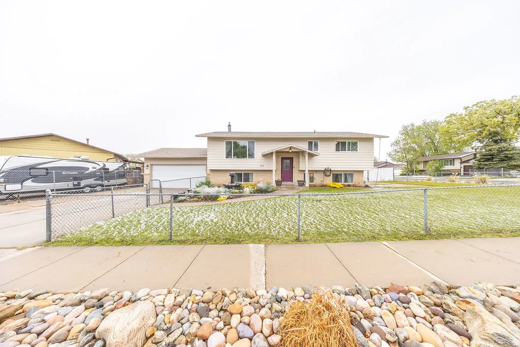 Bi-level home featuring a fenced front yard, driveway, and an attached garage