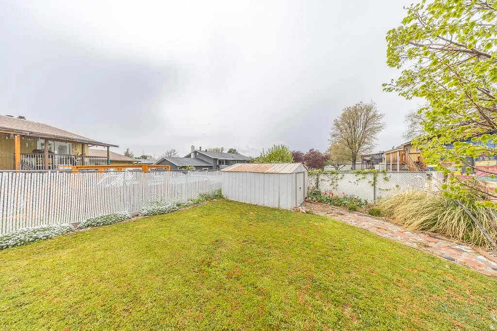 Fenced backyard featuring a shed