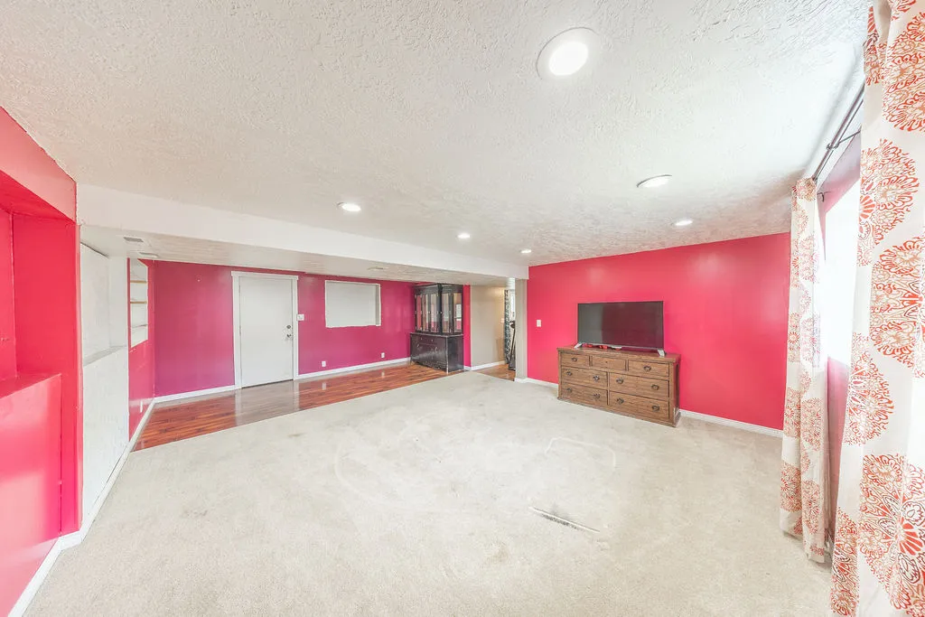 Unfurnished living room with a textured ceiling, carpet, and recessed lighting