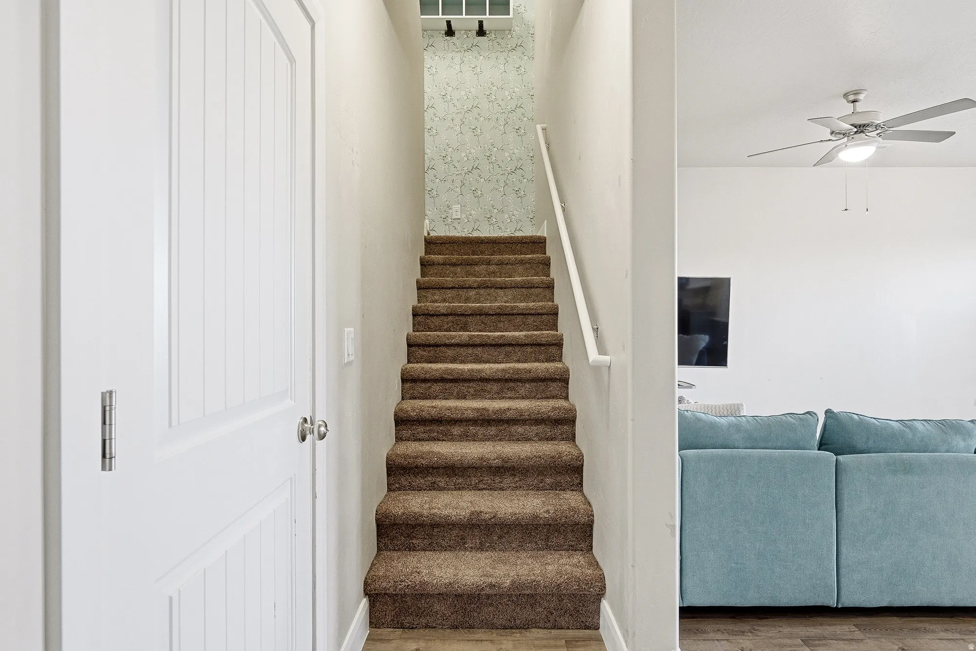 Stairway featuring a ceiling fan and wood finished floors