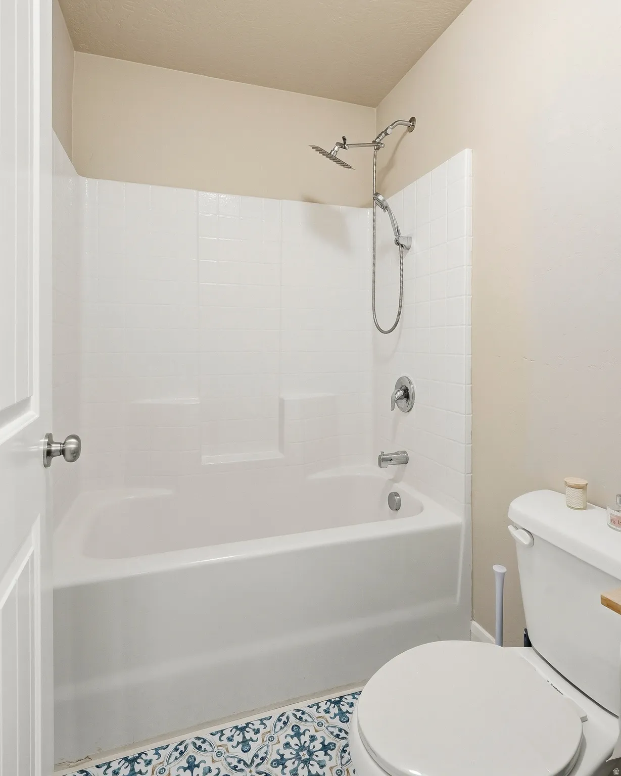 White bathtub and shower combination with chrome fixtures