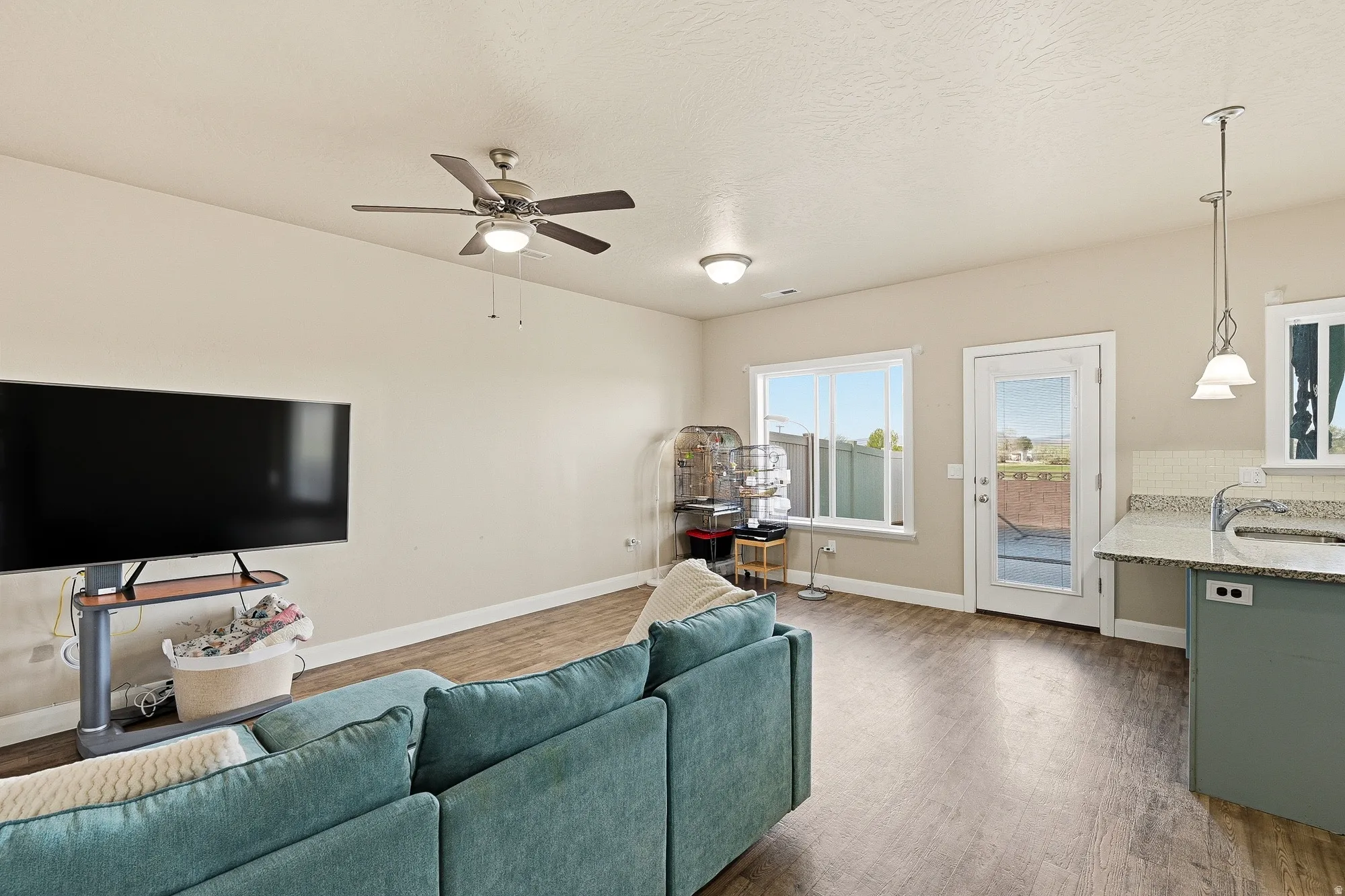Living area featuring dark wood finished floors and a ceiling fan