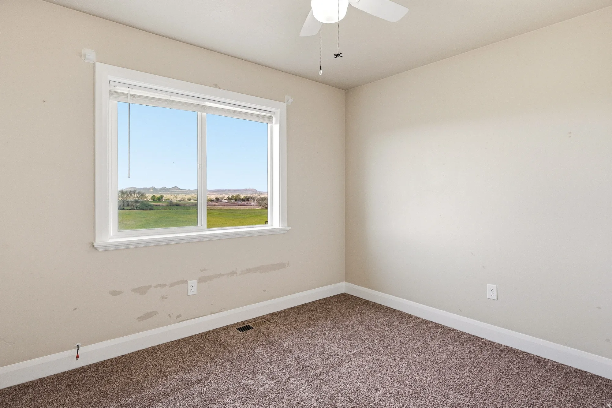 Carpeted empty room with baseboards and ceiling fan