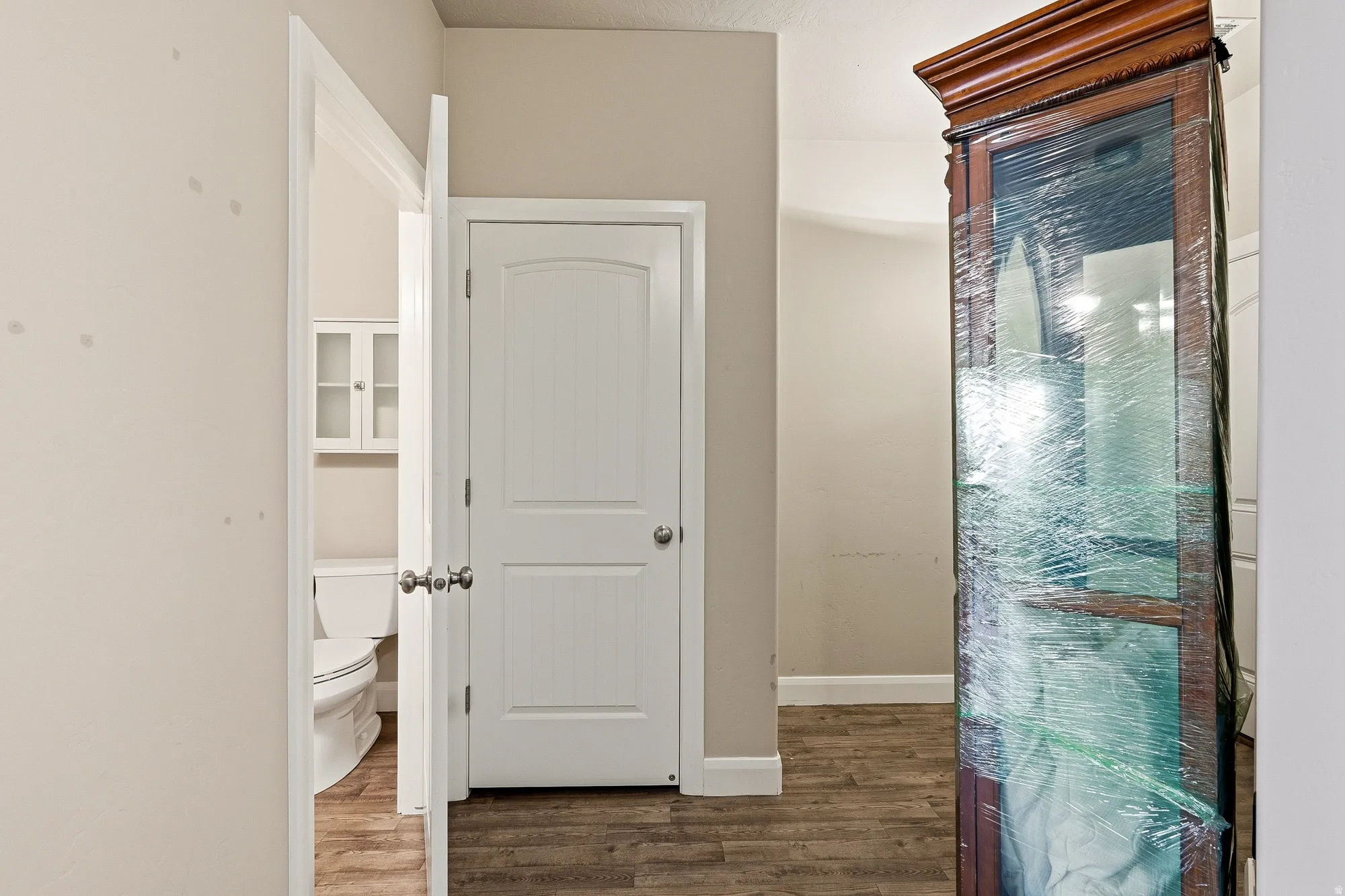 Corridor featuring dark wood-type flooring and baseboards