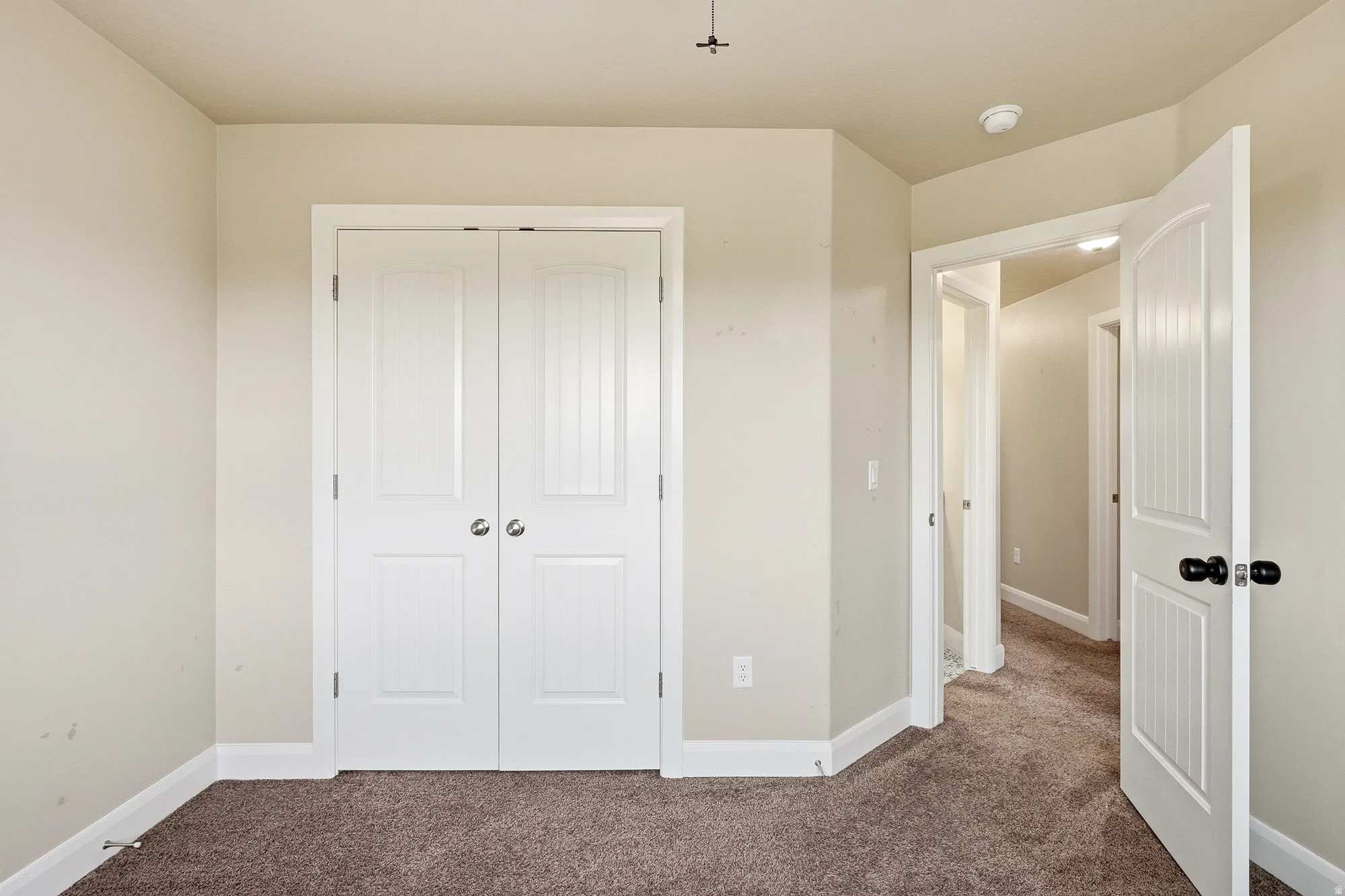 Unfurnished bedroom featuring dark colored carpet and a closet
