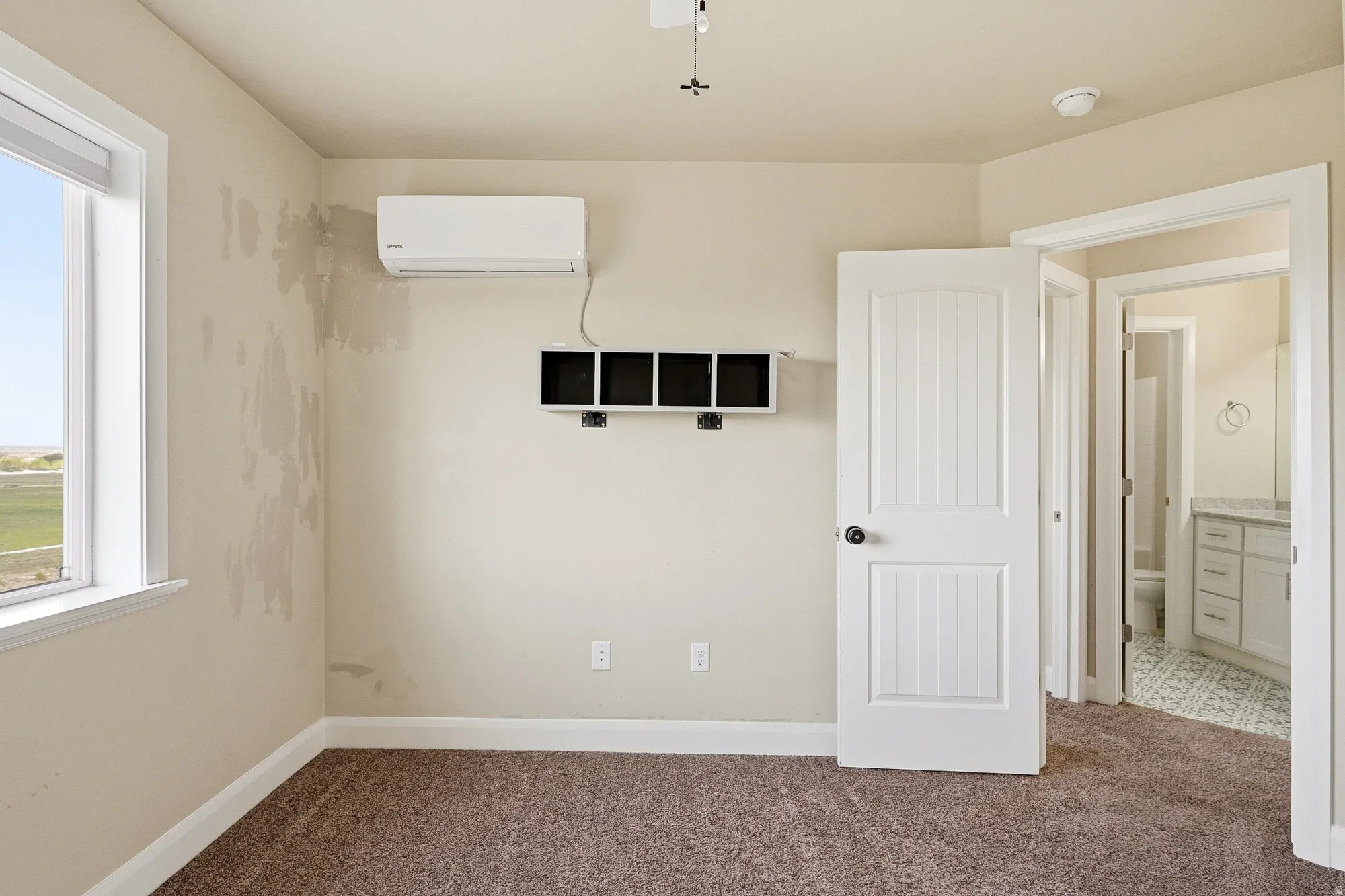 Unfurnished bedroom featuring dark colored carpet and ensuite bath