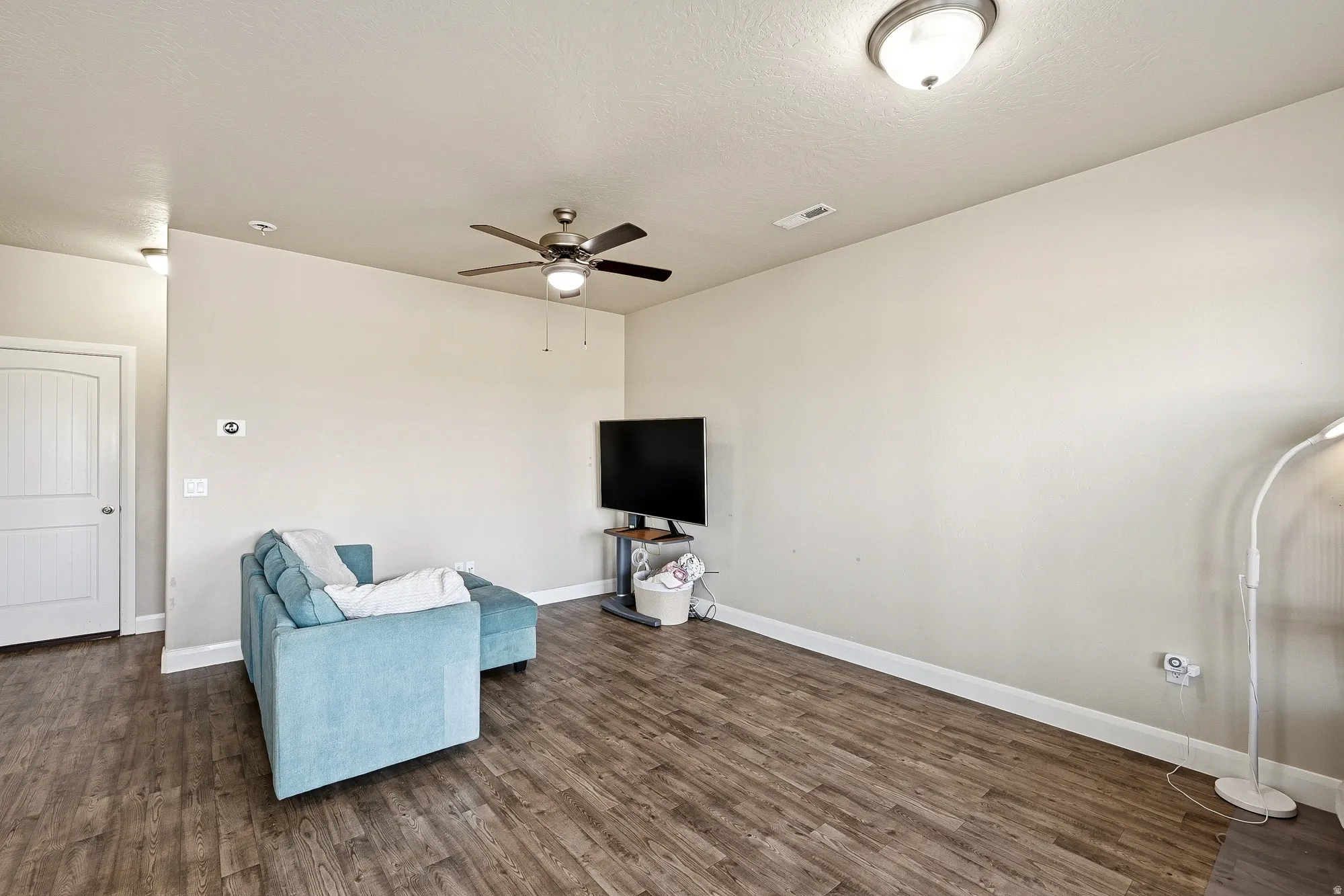 Unfurnished room with dark wood-style flooring and ceiling fan