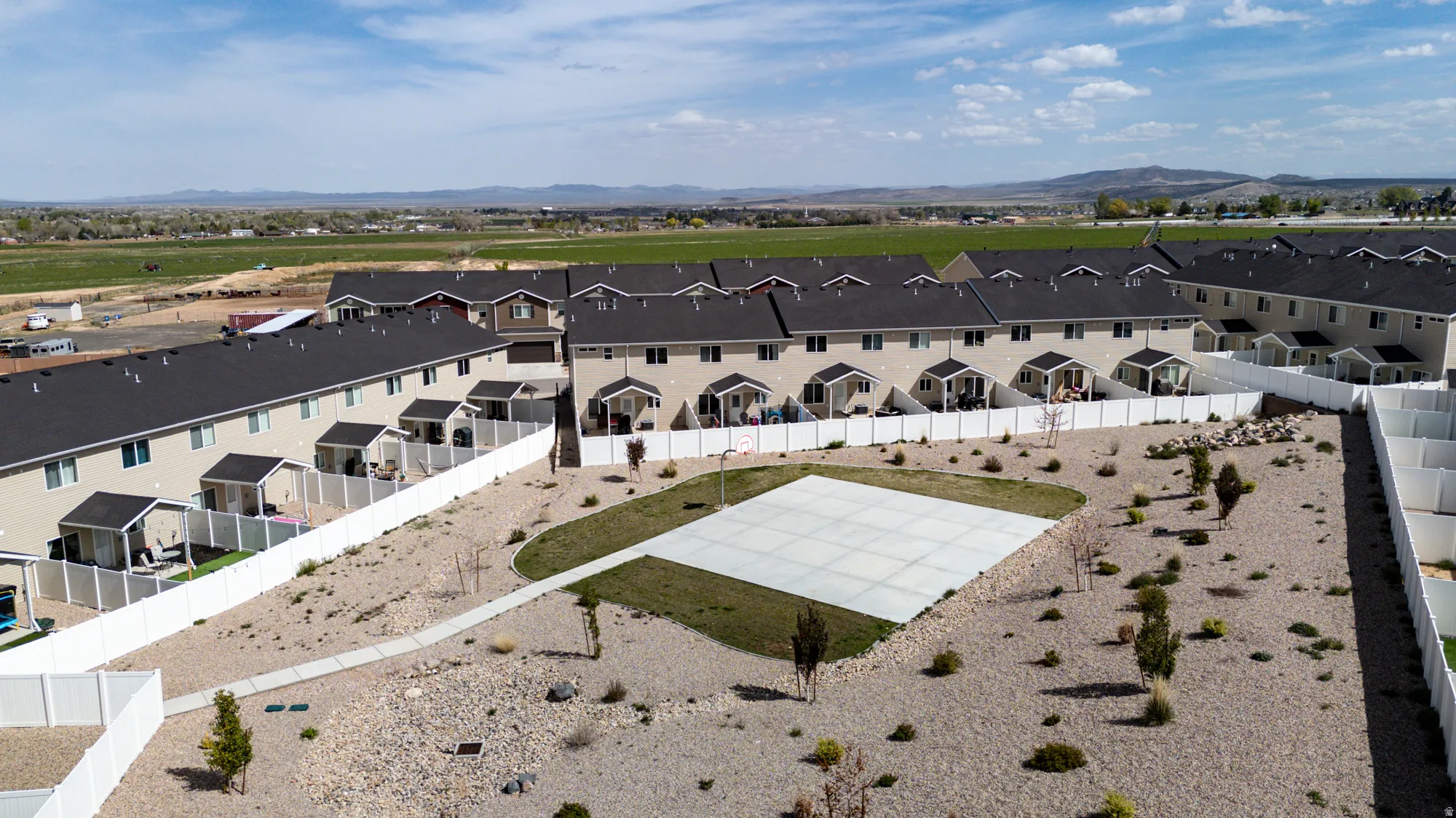 Community area featuring a concrete pad and landscaped rock and shrubbery