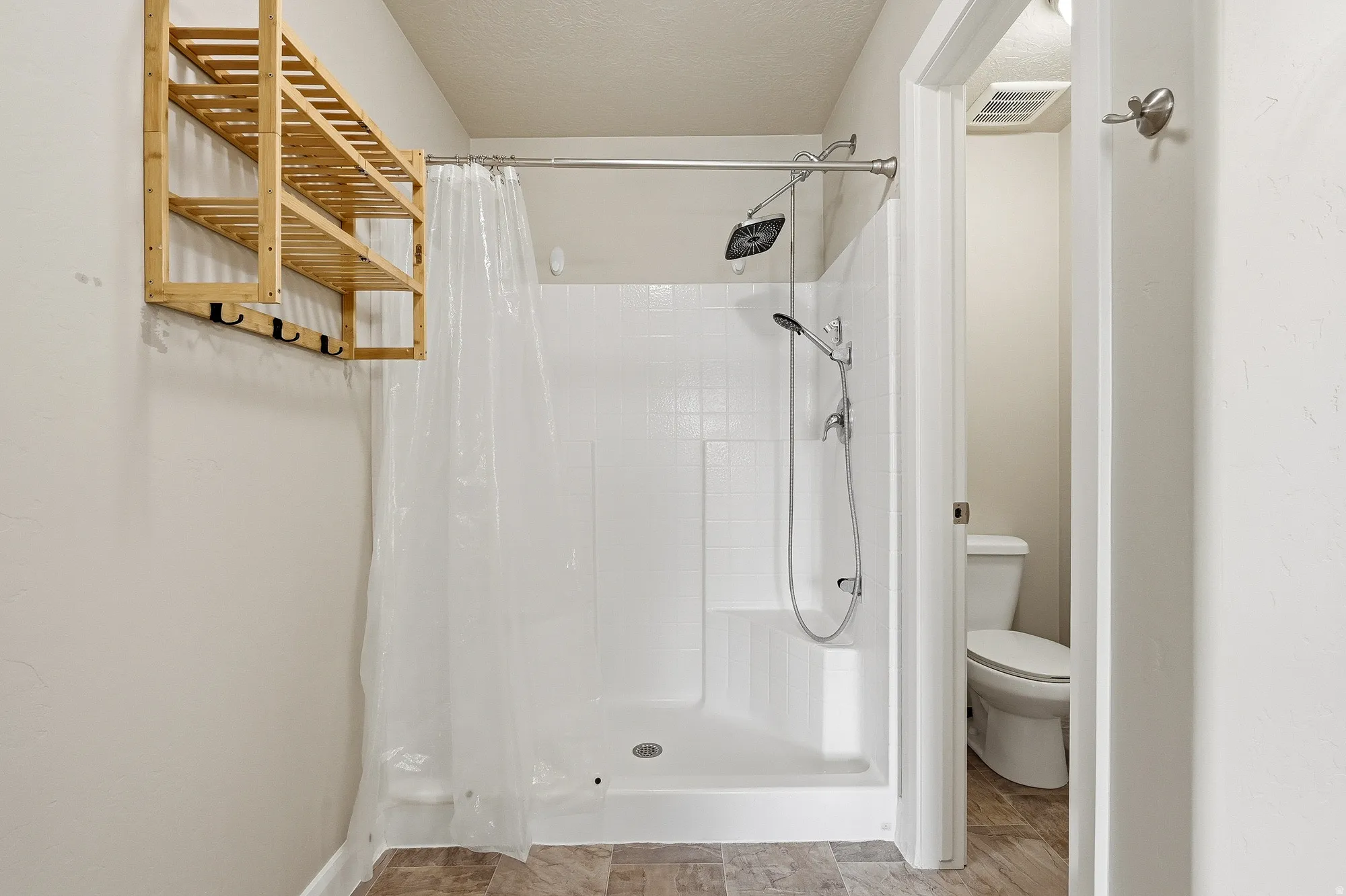 Bathroom featuring a stall shower and a textured ceiling