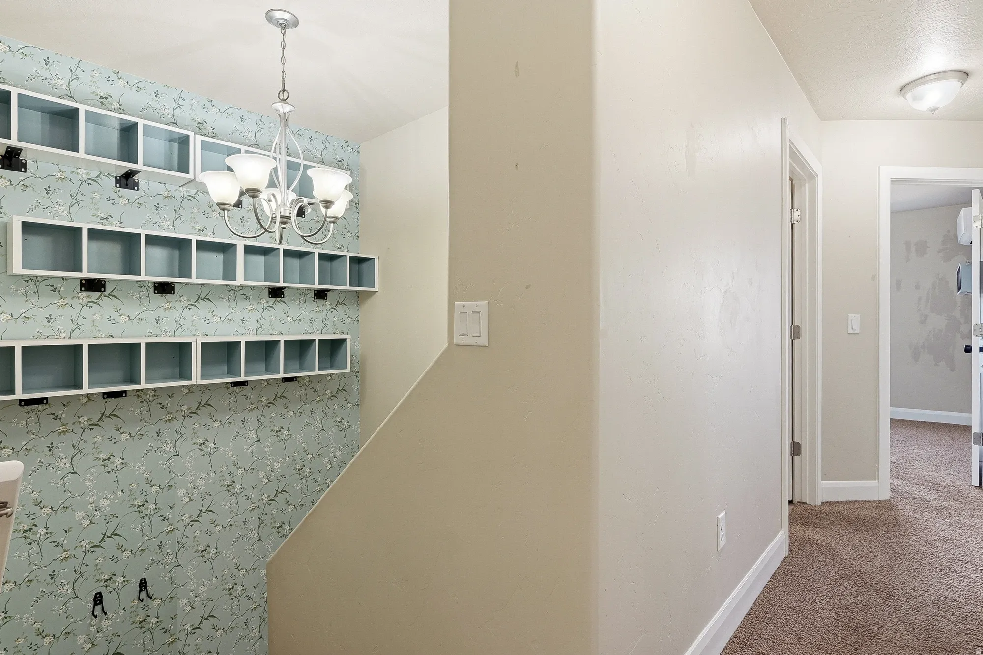 Hall featuring hanging lights and carpet flooring