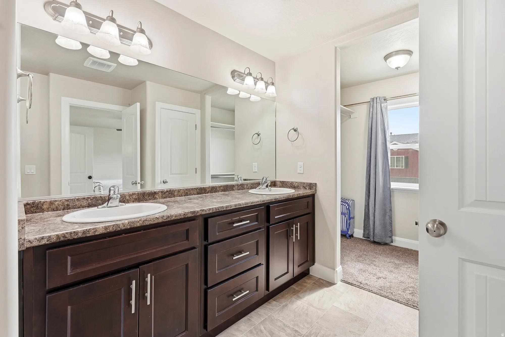 Double vanity with dark wood-finish cabinetry and ample storage