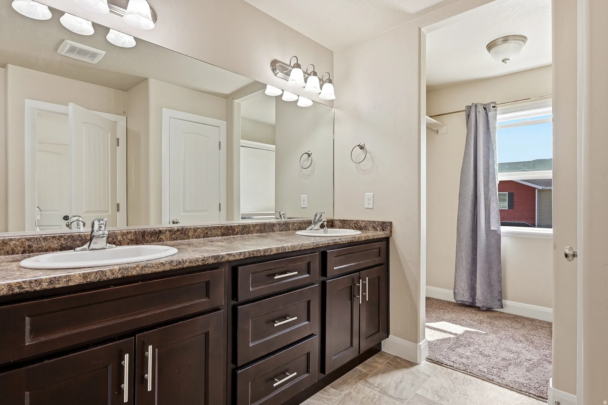 Bathroom with double vanity and baseboards