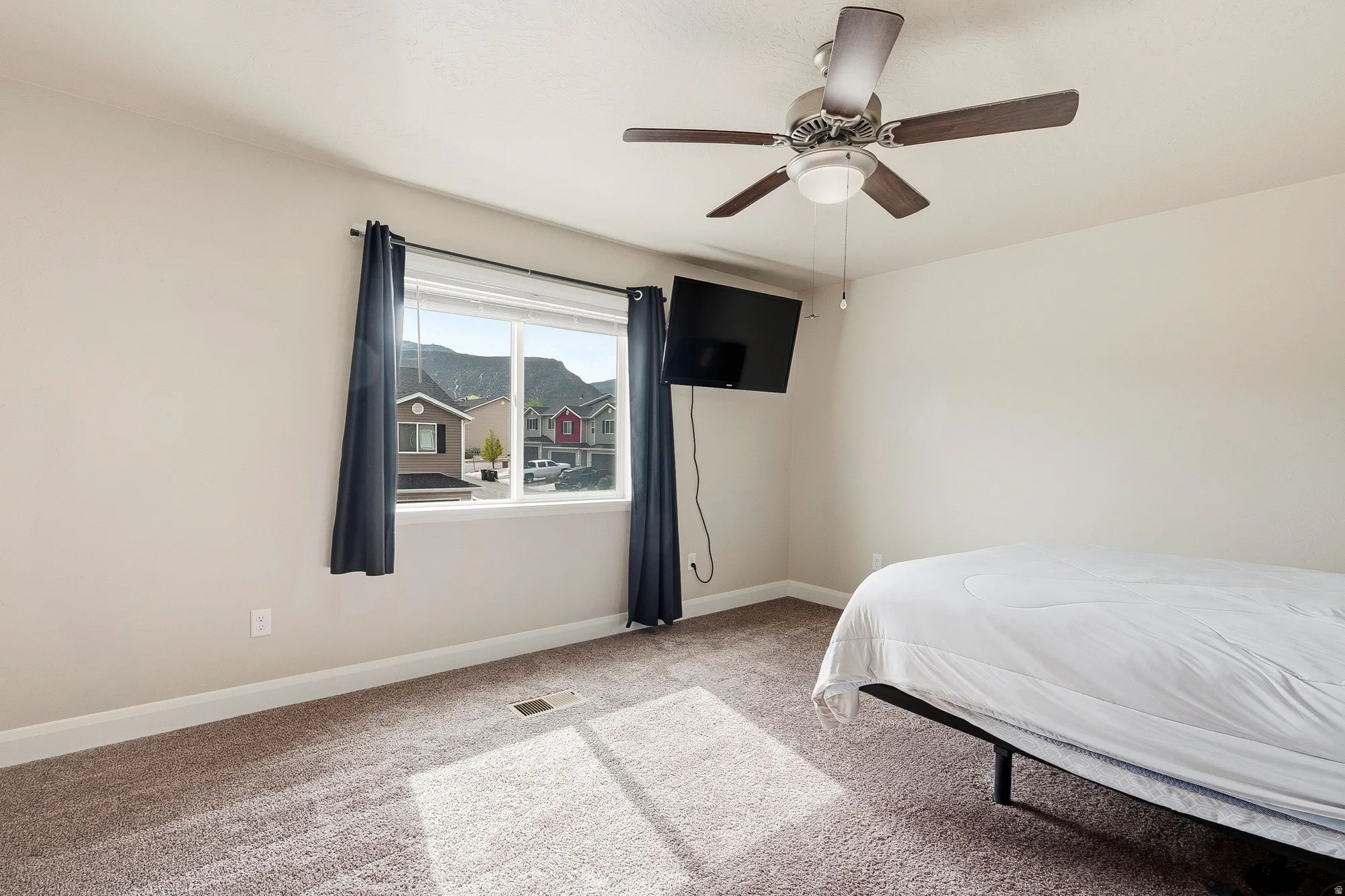 Carpeted room featuring a ceiling fan with integrated lighting, a double window, and white baseboards