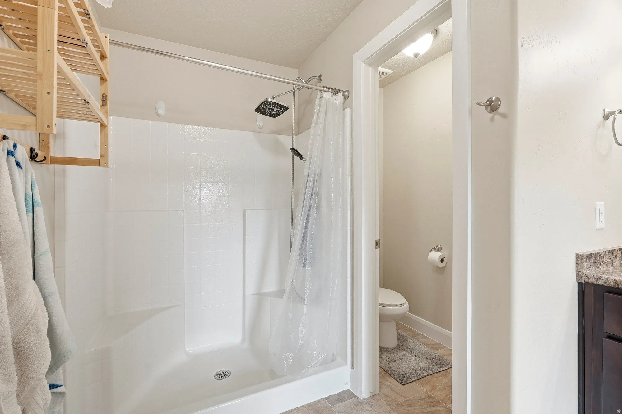 White shower-over-tub combination with a showerhead and handheld sprayer