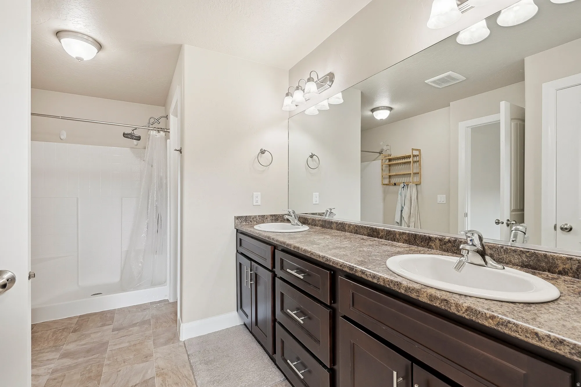 Bathroom featuring a double vanity with dark wood-finish cabinetry and a spacious countertop