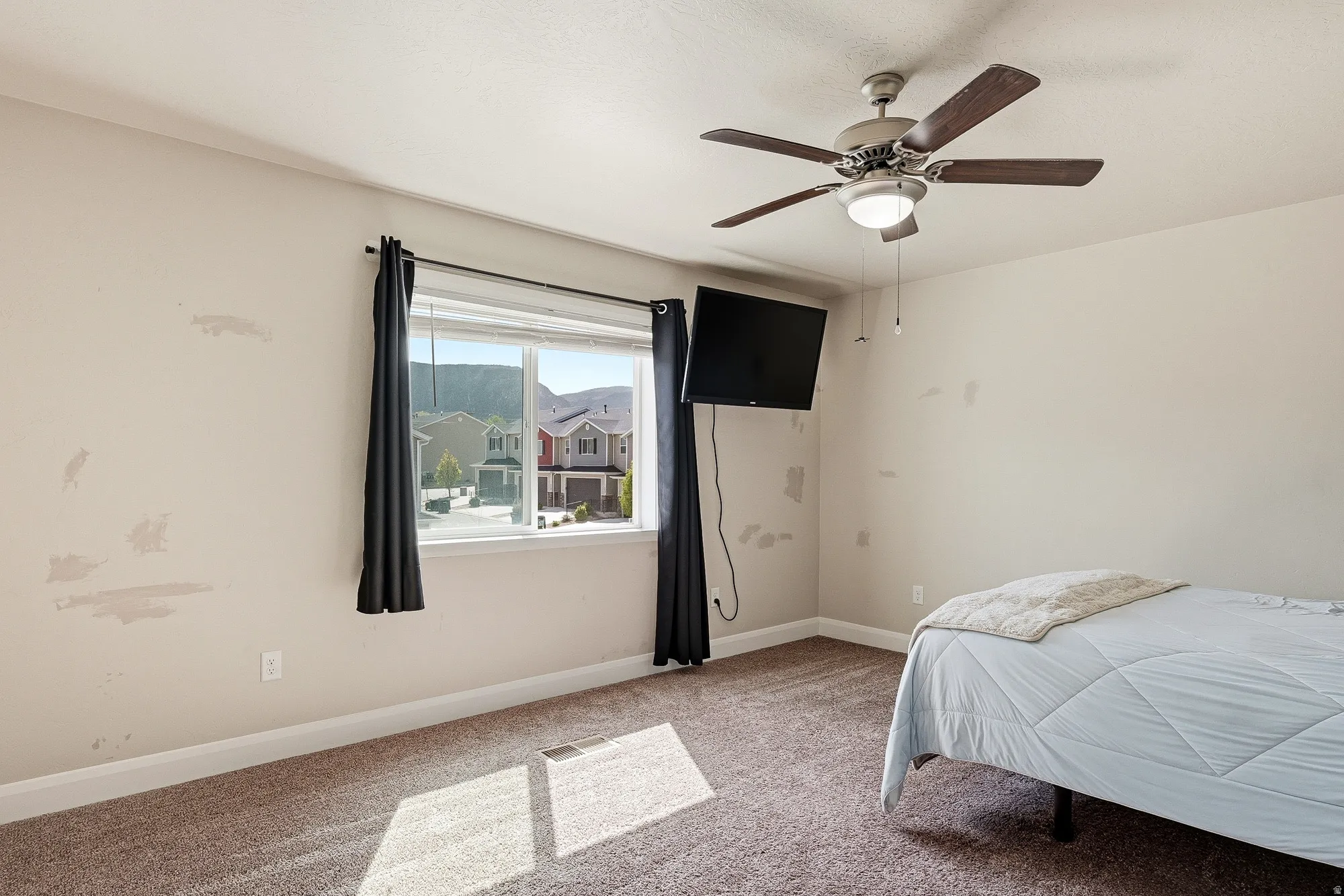Bedroom with light carpet and a ceiling fan