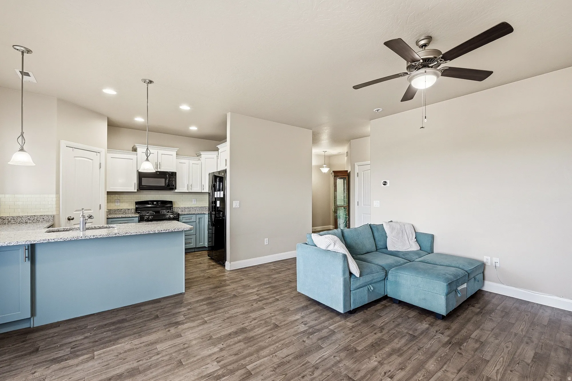 Living room featuring dark wood-style floors, ceiling fan, and recessed lighting