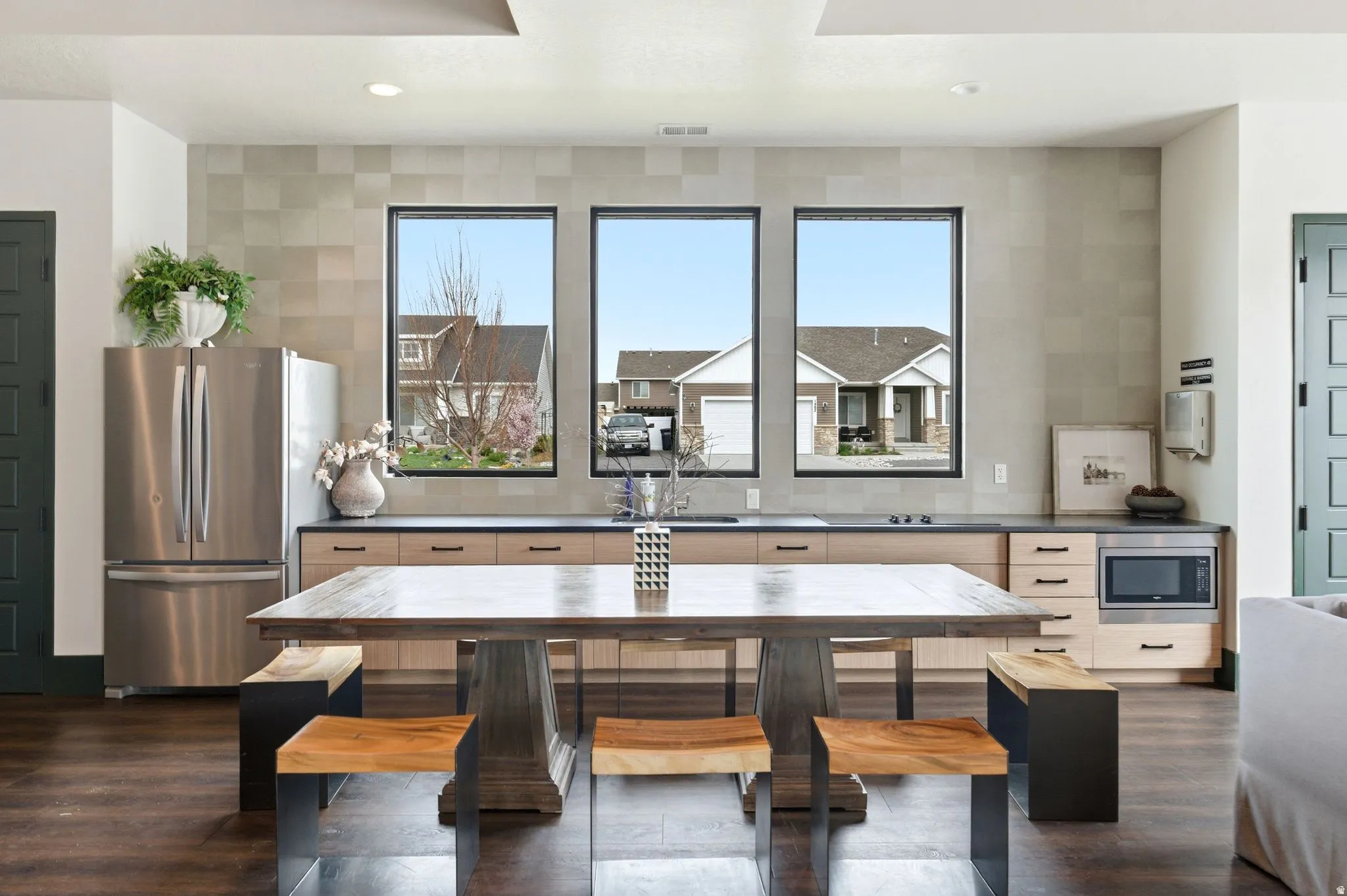 Kitchen with dark countertops, stainless steel appliances, dark wood-type flooring, plenty of natural light, and recessed lighting